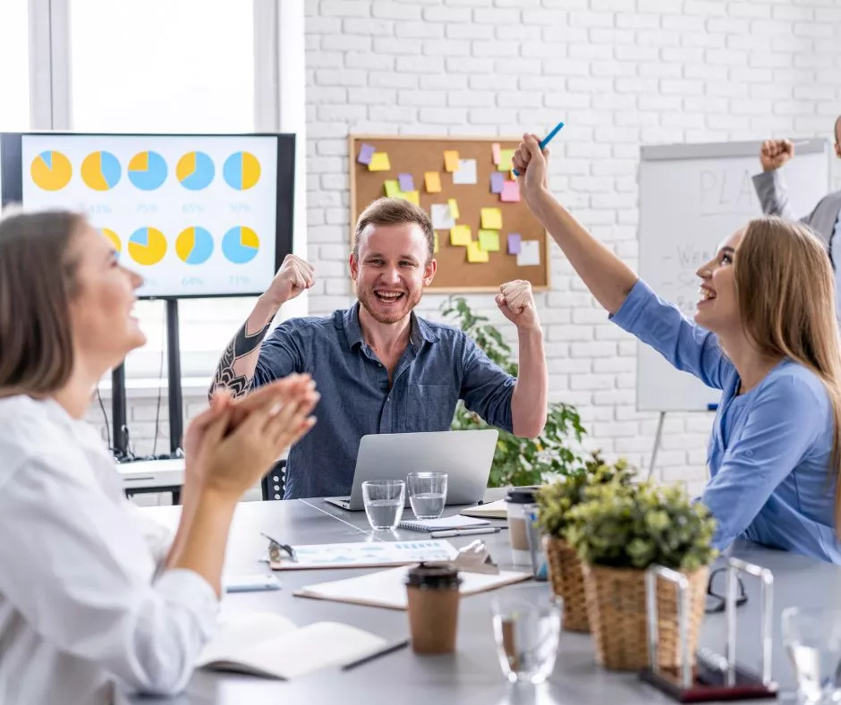 Jóvenes colaboradores celebrando que recibieron un incentivo laboral por el éxito de su proyecto