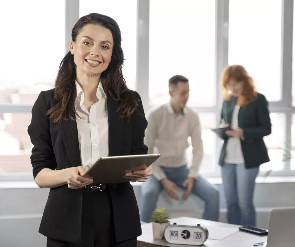Mujer de negocios sonriendo en la oficina sosteniendo una carpeta