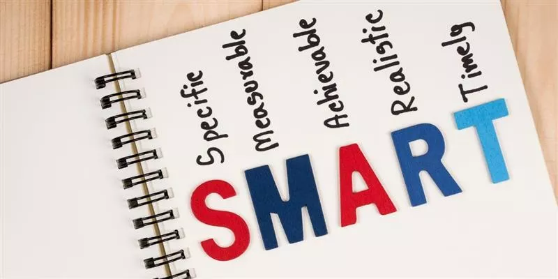 Cuaderno con la palabra SMART y sus componentes, representando el método para definir objetivos SMART claros, medibles y alineados en las empresas.