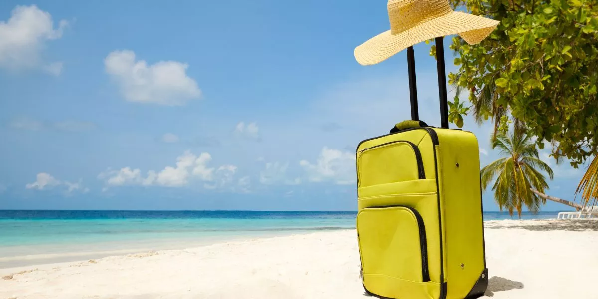 Valija en la playa como símbolo del descanso y las vacaciones laborales.