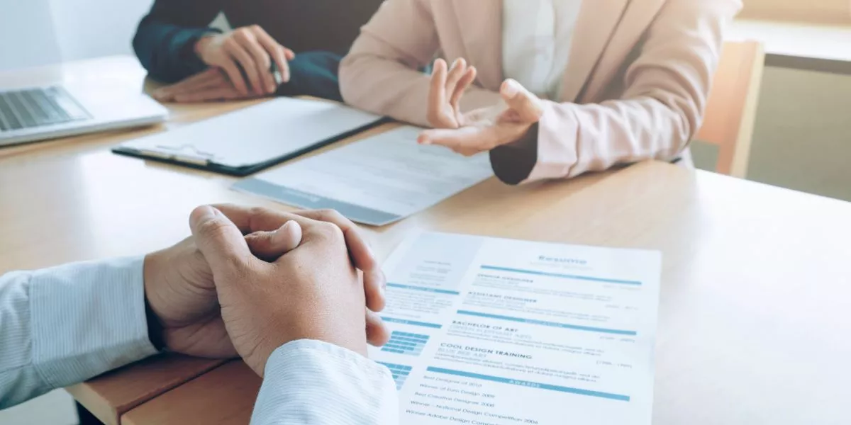 Entrevista de trabajo con revisión de un currículum vitae sobre la mesa, en un contexto de decisiones de contratación en empresas peruanas.