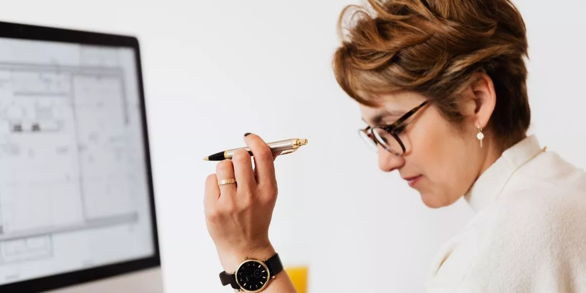 Mujer en oficina evaluando opciones de beneficios corporativos en Perú frente a una computadora, analizando propuestas de proveedores para empresas.