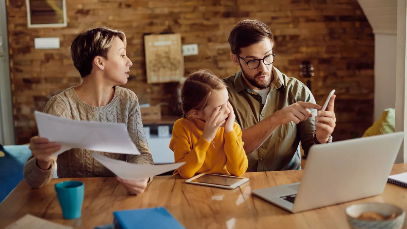 Persona trabajando mientras comparte tiempo con su familia, como ejemplo de conciliación de la vida familiar y laboral.