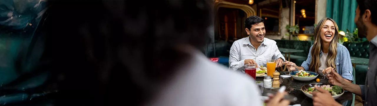 La imagen muestra a un grupo de personas almorzando durante la pausa laboral
