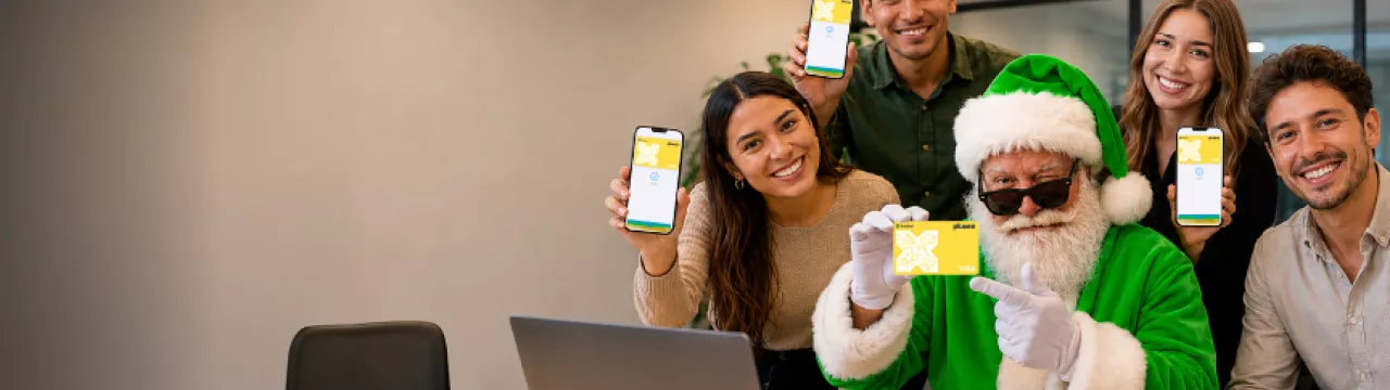 Papá Noel presenta los productos de Pluxee junto a trabajadores en una oficina.