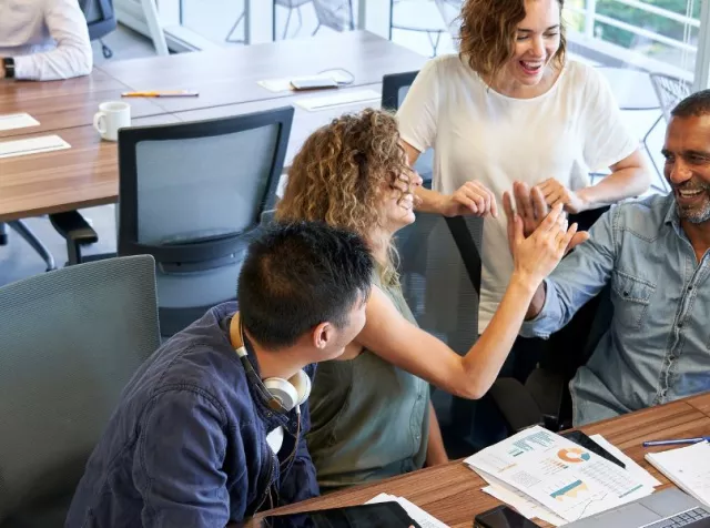 Grupo de personas colaborando y sonriendo en una oficina