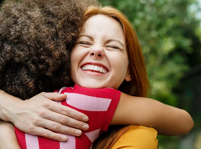 Foto muestra a dos amigas abrazándose