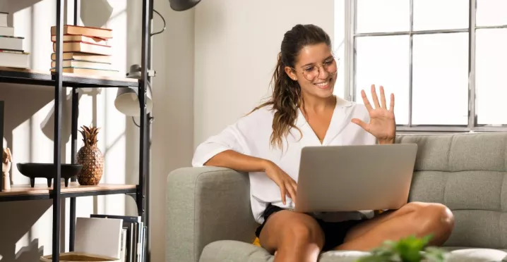 Persona trabajando desde casa en una videollamada, representando el modelo de trabajo híbrido y la flexibilidad laboral.