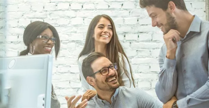 Equipo de personas colaborando en una oficina, representando el compromiso laboral y los factores que influyen en la rotación de personal en las empresas.