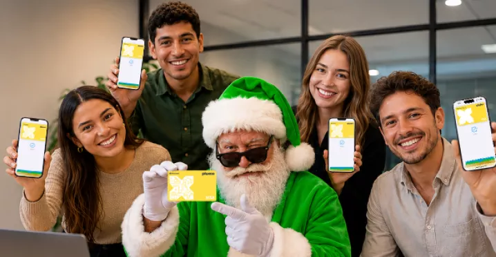 Papá Noel presenta los productos de Pluxee junto a trabajadores en una oficina.