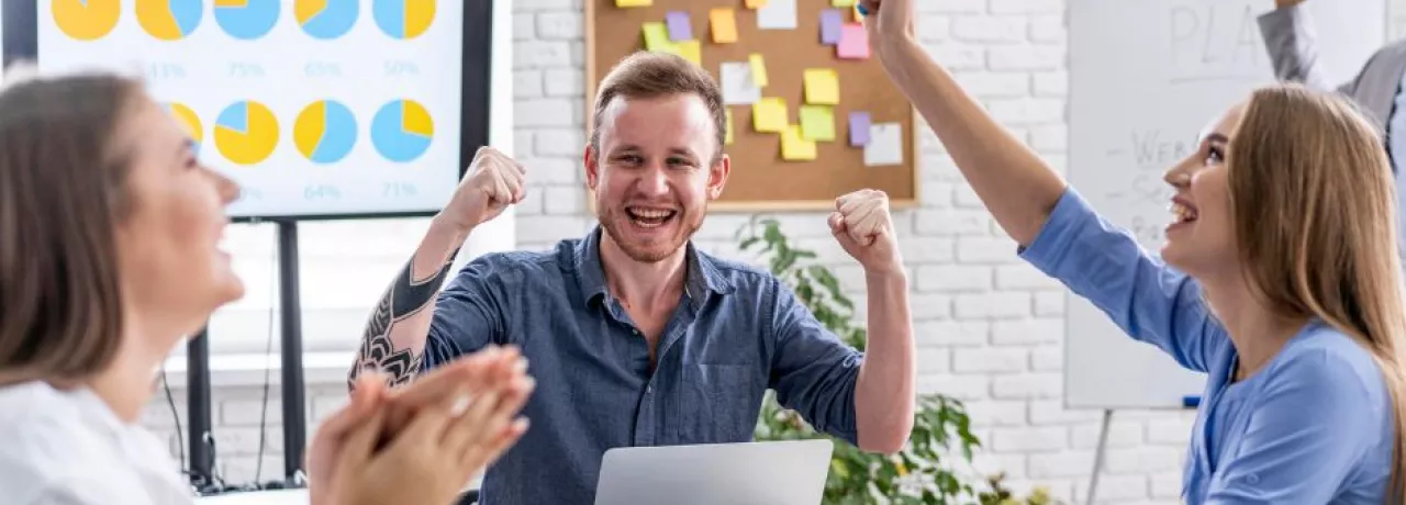 Jóvenes colaboradores celebrando que recibieron un incentivo laboral por el éxito de su proyecto