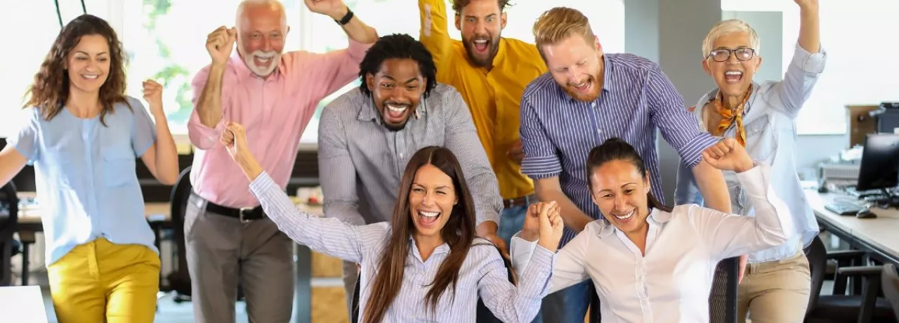 Equipo de trabajo celebrando en la oficina como parte de actividades de team building y formación de equipos.