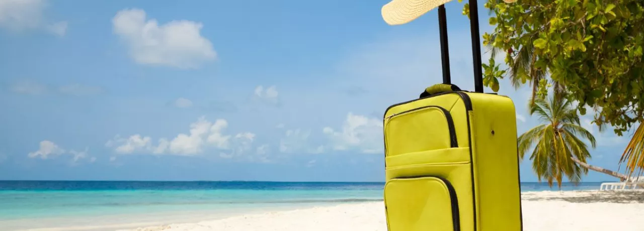 Valija en la playa como símbolo del descanso y las vacaciones laborales.