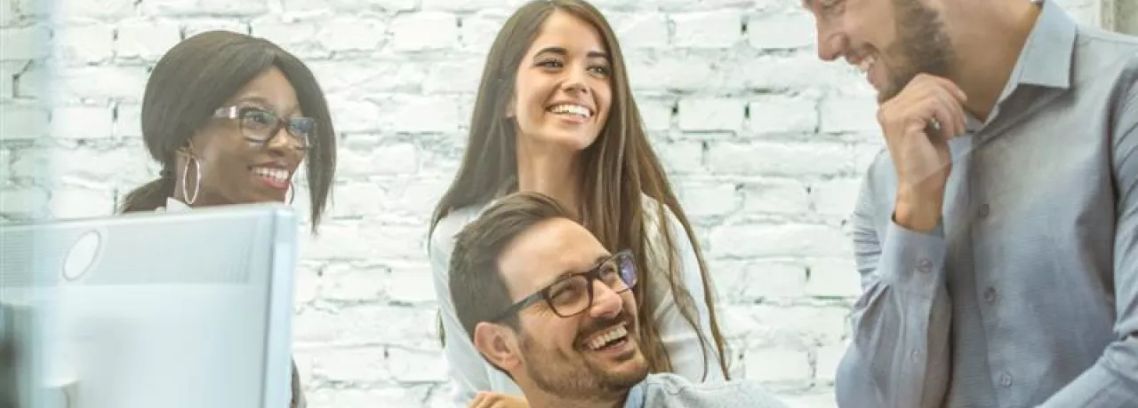 Equipo de personas colaborando en una oficina, representando el compromiso laboral y los factores que influyen en la rotación de personal en las empresas.