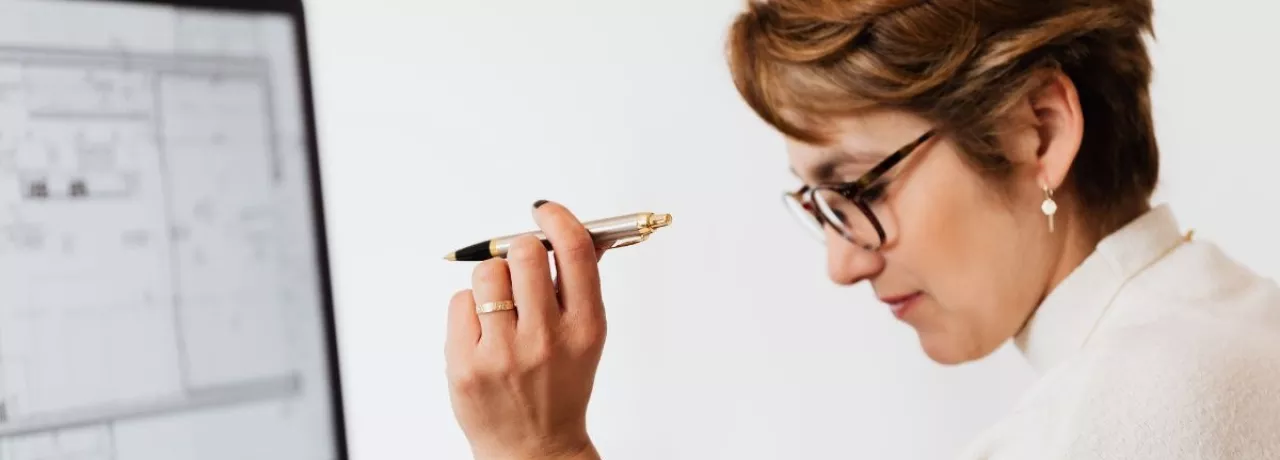 Mujer en oficina evaluando opciones de beneficios corporativos en Perú frente a una computadora, analizando propuestas de proveedores para empresas.