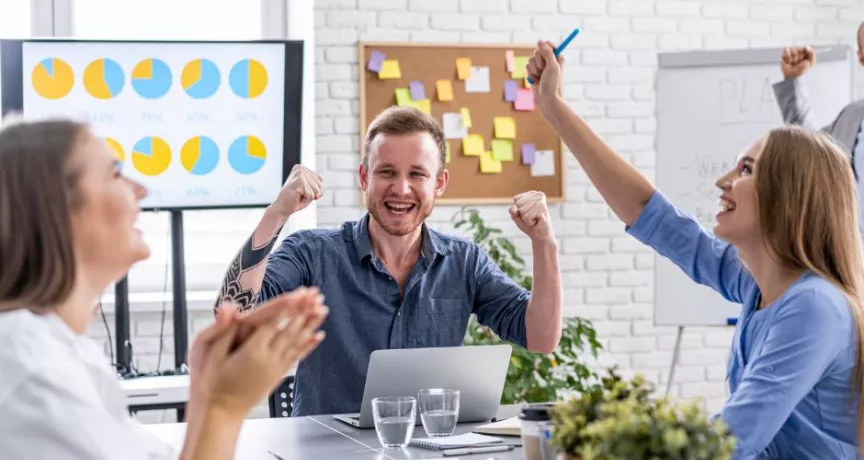 Jóvenes colaboradores celebrando que recibieron un incentivo laboral por el éxito de su proyecto