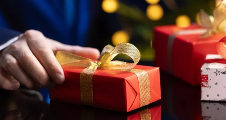 hombre sosteniendo un regalo navideño corporativo en su mano