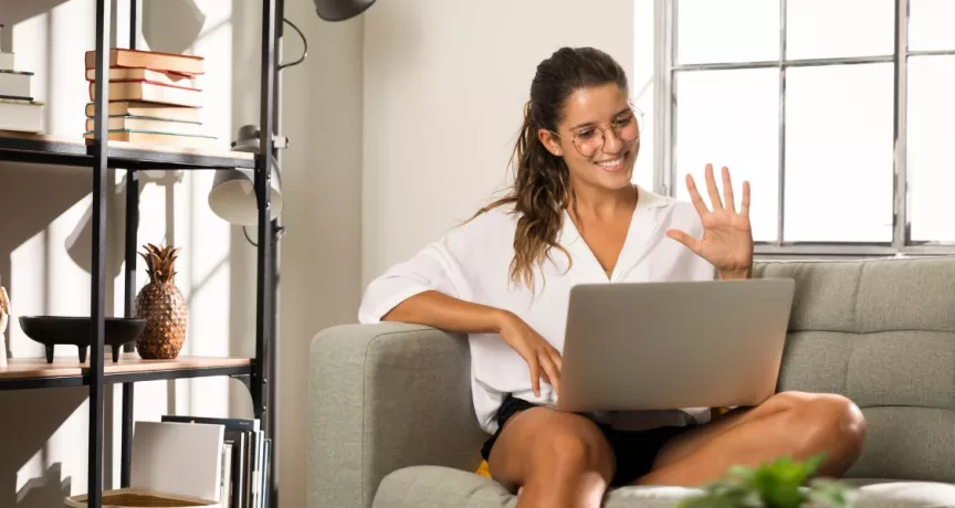 Persona trabajando desde casa en una videollamada, representando el modelo de trabajo híbrido y la flexibilidad laboral.