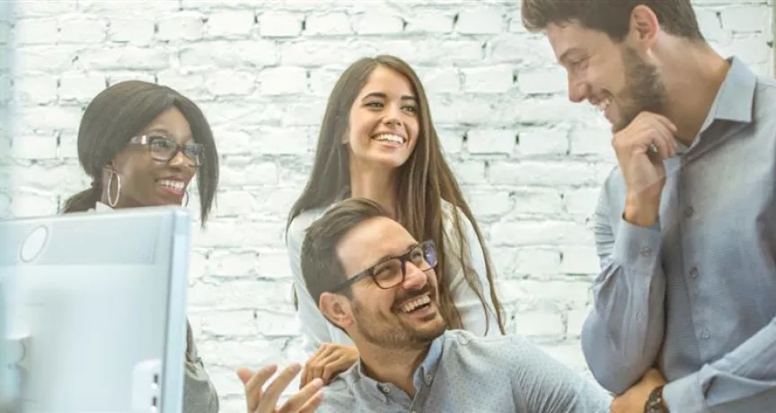 Equipo de personas colaborando en una oficina, representando el compromiso laboral y los factores que influyen en la rotación de personal en las empresas.