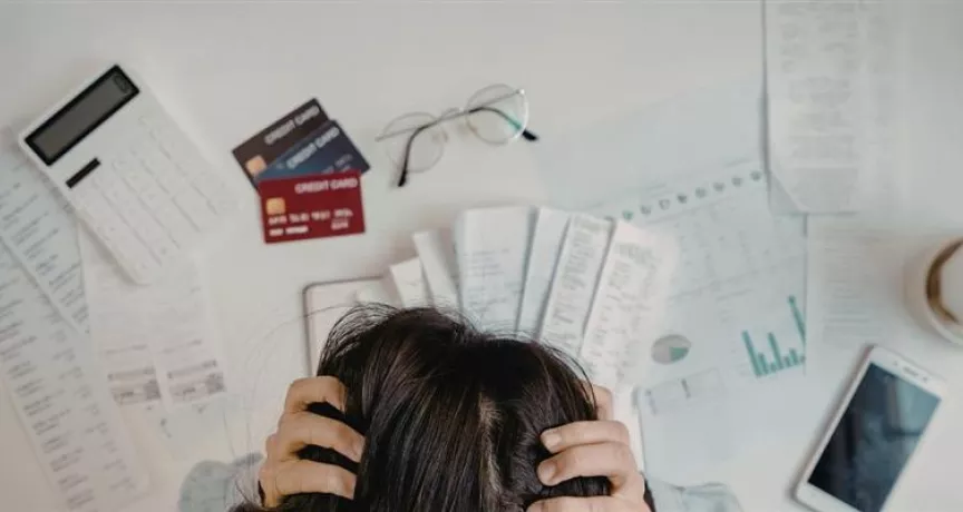 Colaborador revisando sus finanzas en la oficina, ejemplo de cómo el estrés financiero puede afectar el bienestar laboral.