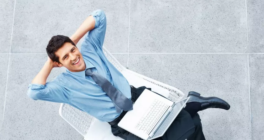 Colaborador con una computadora portátil descansando durante su jornada, en representación de la semana laboral de 4 días.