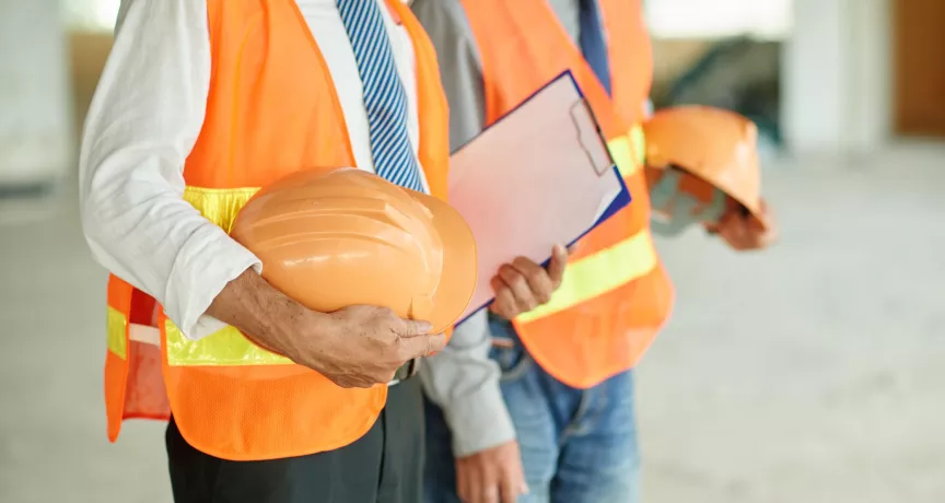 Trabajadores con chalecos de seguridad y cascos como parte de la prevención en salud ocupacional