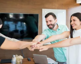 Equipo de trabajo colaborando con entusiasmo en una reunión, simbolizando beneficios laborales y salario emocional en empresas modernas