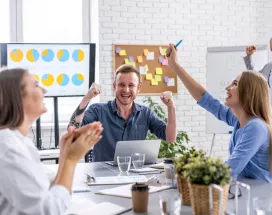 Jóvenes colaboradores celebrando que recibieron un incentivo laboral por el éxito de su proyecto