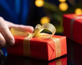 hombre sosteniendo un regalo navideño corporativo en su mano