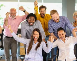Equipo de trabajo celebrando en la oficina como parte de actividades de team building y formación de equipos.
