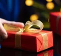 hombre sosteniendo un regalo navideño corporativo en su mano