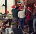 Colaboradores en la oficina decorando juntos el árbol navideño