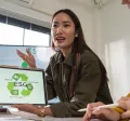 Profesional mostrando en una tablet una presentación sobre pilares ESG durante una reunión laboral, mientras explica estrategias de sostenibilidad al equipo.