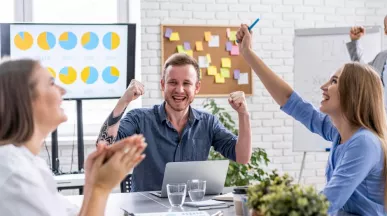 Jóvenes colaboradores celebrando que recibieron un incentivo laboral por el éxito de su proyecto