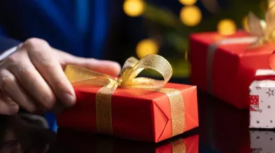 hombre sosteniendo un regalo navideño corporativo en su mano