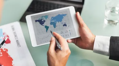 Profesional analizando datos del mercado global en una tablet durante la jornada laboral