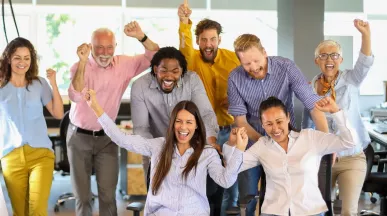 Equipo de trabajo celebrando en la oficina como parte de actividades de team building y formación de equipos.