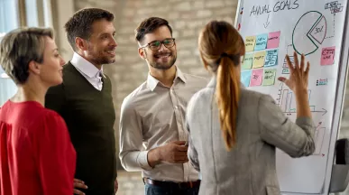 Equipo de trabajo analizando gráficos y datos en pizarra, aplicando habilidades duras para la toma de decisiones en empresa en Perú