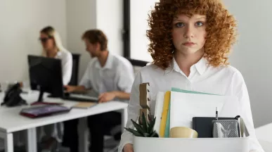 Colaboradora dejando la oficina con una caja de pertenencias tras una renuncia laboral relacionada con la rotación del personal en empresas.