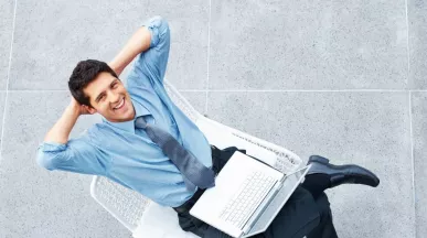 Colaborador con una computadora portátil descansando durante su jornada, en representación de la semana laboral de 4 días.
