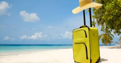 Valija en la playa como símbolo del descanso y las vacaciones laborales.