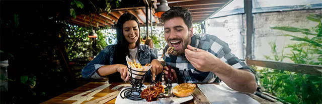 Foto muestra a dos amigos del trabajo almorzando durante el día. 