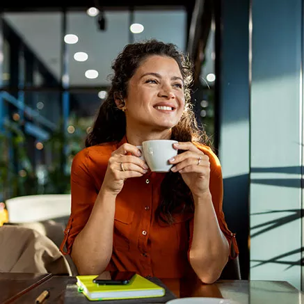 La mujer bebe café tranquilamente en una cafetería