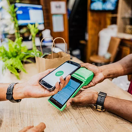 Persona usa celular para pagar por contacto usando Google Pay