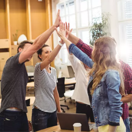 Grupo de personas celebrando una victoria en el trabajo
