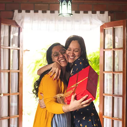 Dos personas abrazándose y sosteniendo un regalo