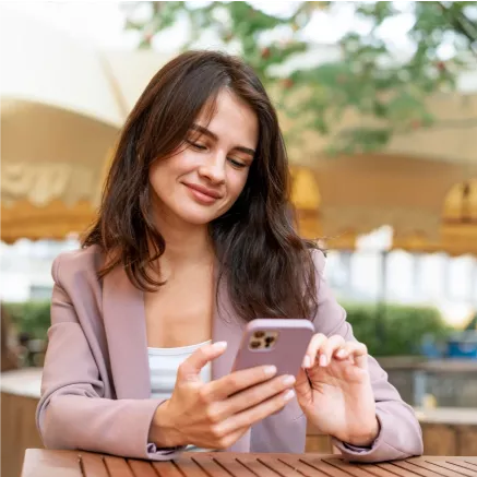 Persona utilizando un smartphone al aire libre para consultar saldos y gestionar beneficios de Pluxee Alimentación de forma rápida y digital.