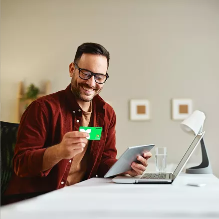 Persona utilizando una tablet y mostrando una tarjeta Pluxee Alimentación, destacando la gestión digital de beneficios y compras de alimentos.
